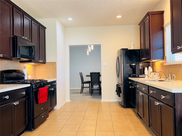 kitchen with tasteful backsplash, dark brown cabinets, sink, black appliances, and light tile patterned flooring