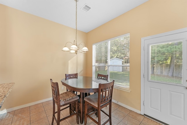 dining area with light tile patterned floors and an inviting chandelier