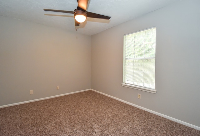 empty room featuring ceiling fan and carpet