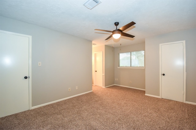 unfurnished bedroom with a textured ceiling, light colored carpet, and ceiling fan