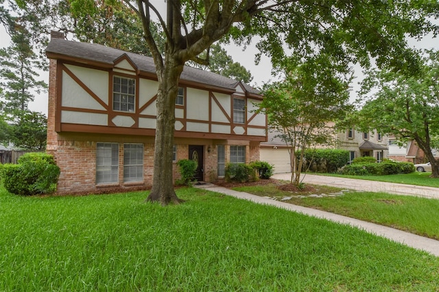 tudor house featuring a garage and a front yard