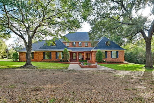 colonial inspired home featuring a patio and a front lawn