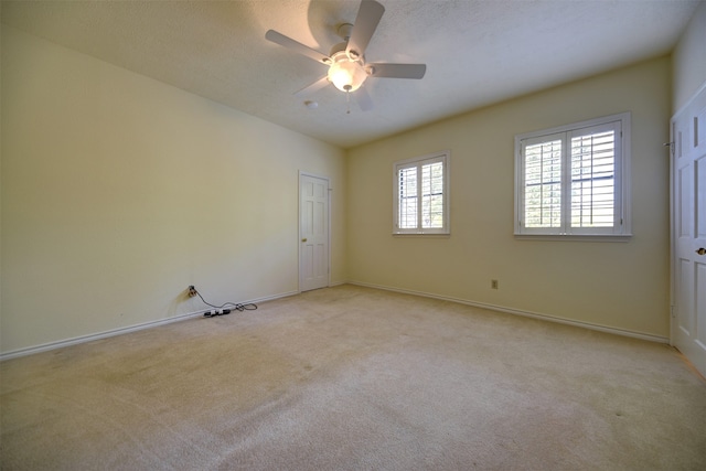 carpeted spare room with ceiling fan and a textured ceiling