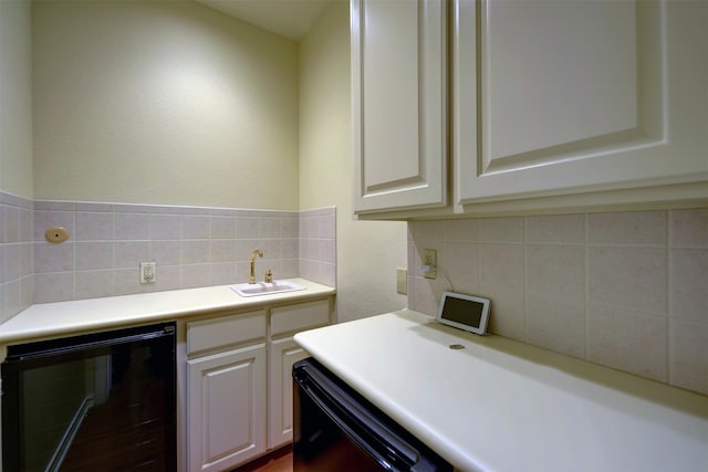 kitchen with white cabinets, black dishwasher, tasteful backsplash, and beverage cooler