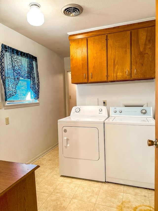 laundry room featuring cabinets, independent washer and dryer, and light tile patterned flooring