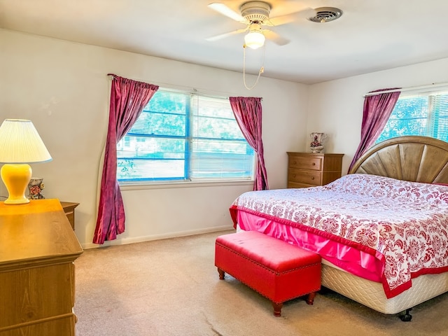 carpeted bedroom with ceiling fan and multiple windows