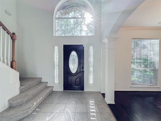 entrance foyer with hardwood / wood-style floors, ornamental molding, and decorative columns