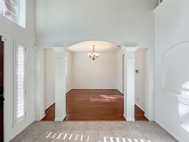 foyer entrance featuring decorative columns, plenty of natural light, and light wood-type flooring