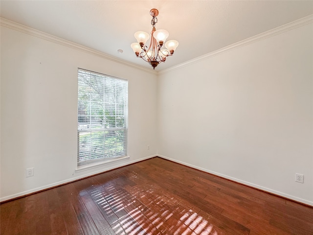 spare room featuring hardwood / wood-style floors, an inviting chandelier, and ornamental molding