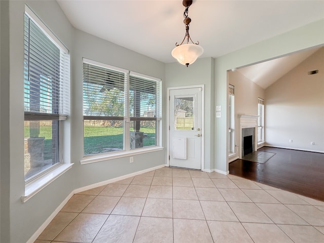 unfurnished dining area with light hardwood / wood-style floors and lofted ceiling