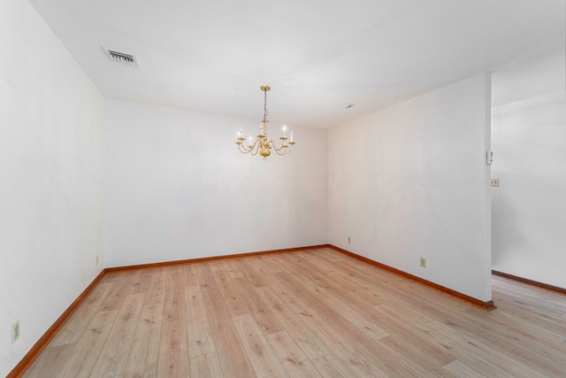 unfurnished room featuring light hardwood / wood-style floors and an inviting chandelier