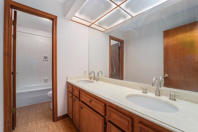 full bathroom with parquet floors, shower / washtub combination, vanity, and toilet