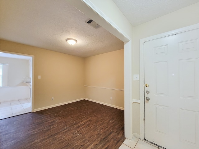 entrance foyer with hardwood / wood-style floors and a textured ceiling