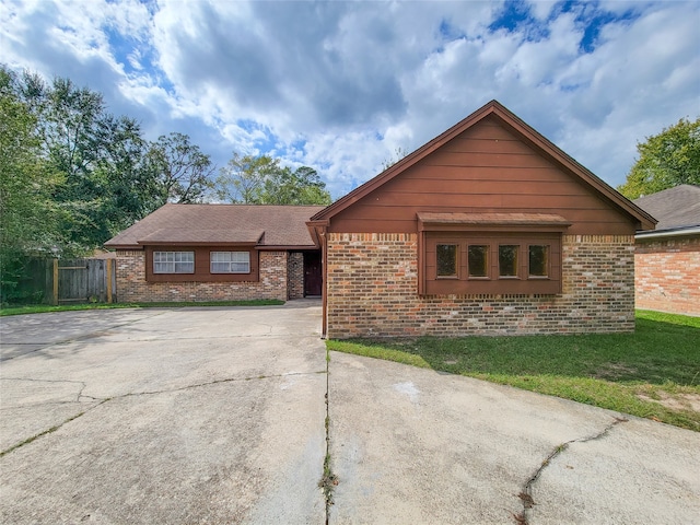 ranch-style home featuring a front lawn