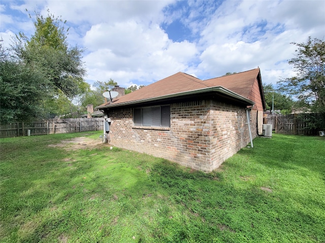 view of side of property with a yard and central air condition unit