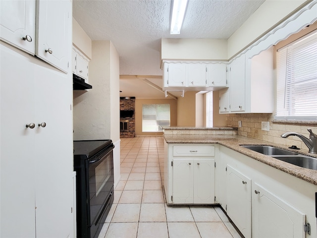 kitchen featuring kitchen peninsula, white cabinetry, sink, and black electric range