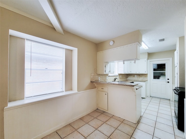 kitchen featuring white cabinetry, beamed ceiling, kitchen peninsula, decorative backsplash, and light tile patterned floors