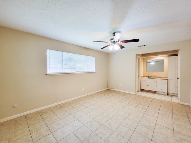 unfurnished bedroom with ceiling fan, light tile patterned flooring, and a textured ceiling