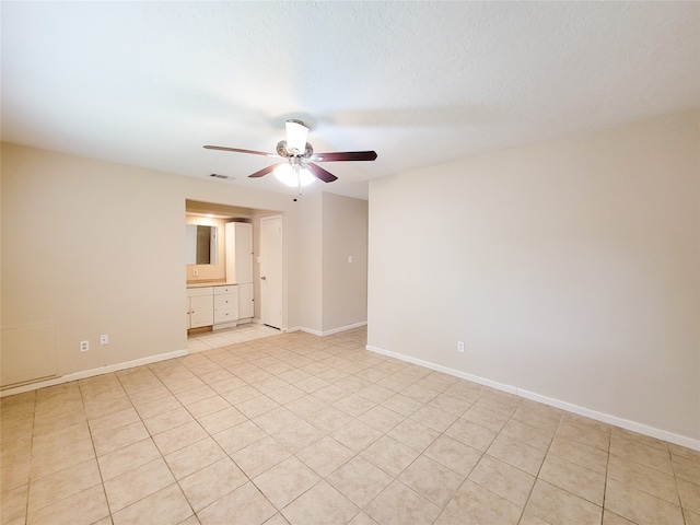 unfurnished room with ceiling fan, light tile patterned floors, and a textured ceiling