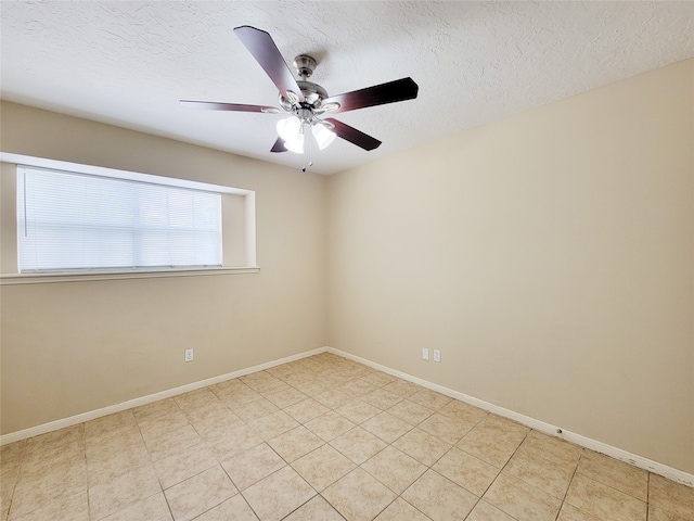 tiled empty room with ceiling fan and a textured ceiling