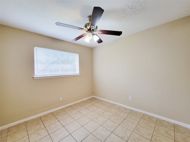 tiled spare room with a textured ceiling and ceiling fan