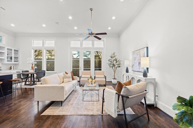 living room with crown molding, ceiling fan, and dark wood-type flooring