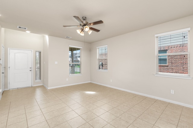 tiled spare room with ceiling fan