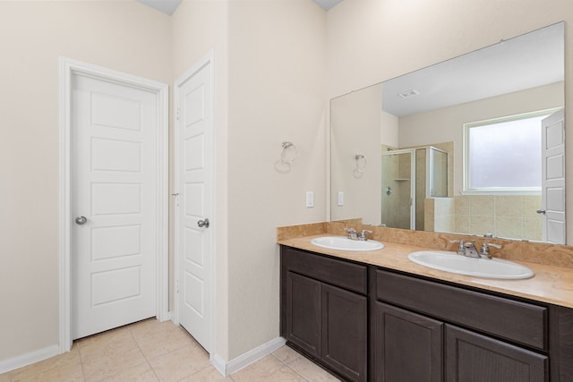 bathroom with tile patterned floors, a shower with door, and vanity