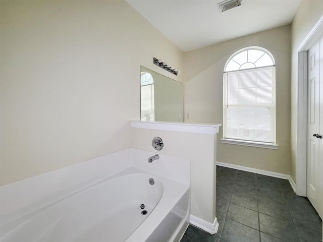 bathroom featuring a washtub and tile patterned flooring