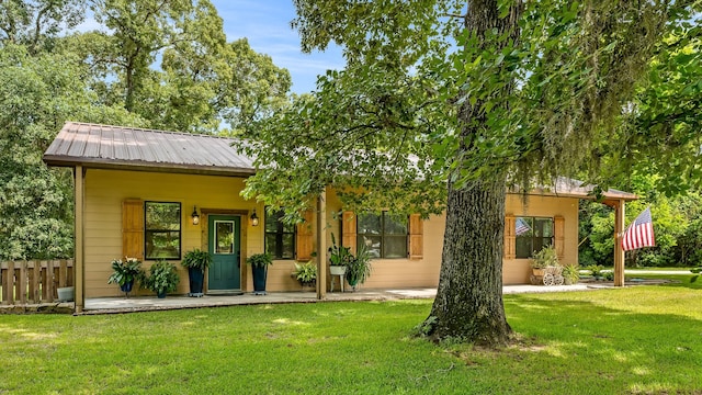 back of property with covered porch and a yard