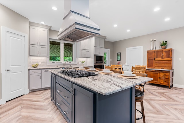 kitchen featuring gray cabinets, premium range hood, black gas cooktop, and light parquet floors