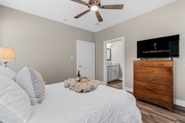 bedroom featuring ensuite bath, ceiling fan, hardwood / wood-style floors, and sink