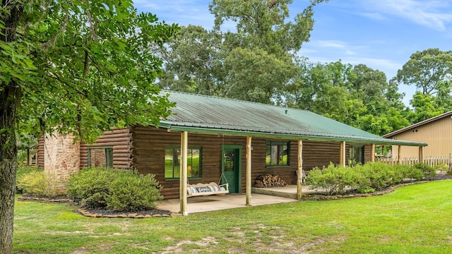 rear view of house with a yard and a patio