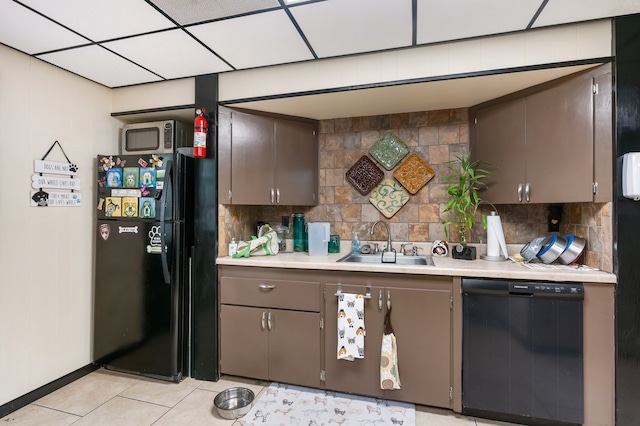 kitchen featuring sink, a drop ceiling, decorative backsplash, dark brown cabinets, and black appliances