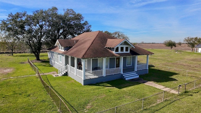 view of front of home with a front yard, a porch, and a rural view