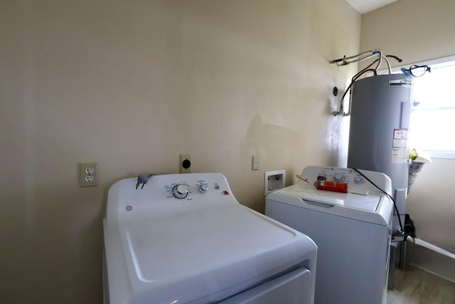 clothes washing area featuring water heater and independent washer and dryer