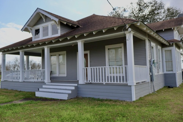 view of property exterior featuring a lawn and covered porch