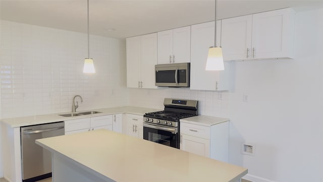 kitchen featuring backsplash, stainless steel appliances, sink, pendant lighting, and white cabinetry