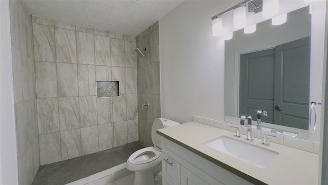 bathroom featuring vanity, toilet, and tiled shower