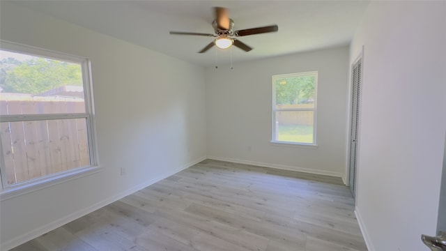 unfurnished room featuring plenty of natural light, ceiling fan, and light hardwood / wood-style flooring