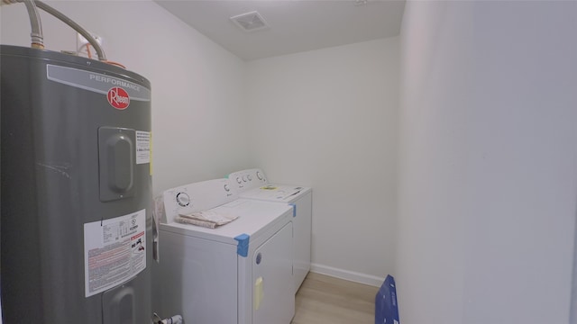 laundry area featuring washer and dryer, light hardwood / wood-style floors, and water heater