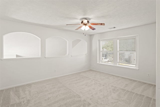 carpeted spare room featuring ceiling fan and a textured ceiling