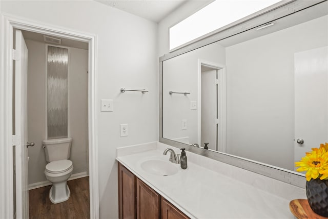 bathroom with hardwood / wood-style floors, vanity, and toilet