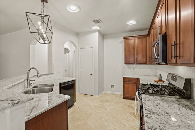 kitchen with light stone countertops, decorative backsplash, stainless steel appliances, sink, and decorative light fixtures