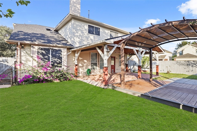 back of property featuring a lawn, a pergola, and a wooden deck