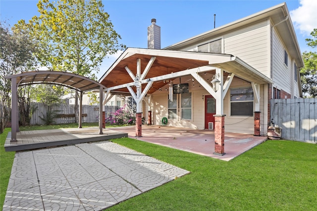 back of property featuring ceiling fan, a patio area, and a lawn