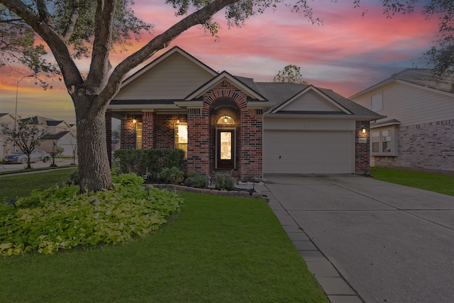 ranch-style house featuring a garage and a lawn