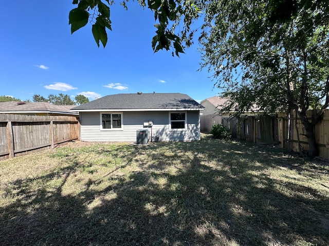 back of property featuring a lawn and central AC