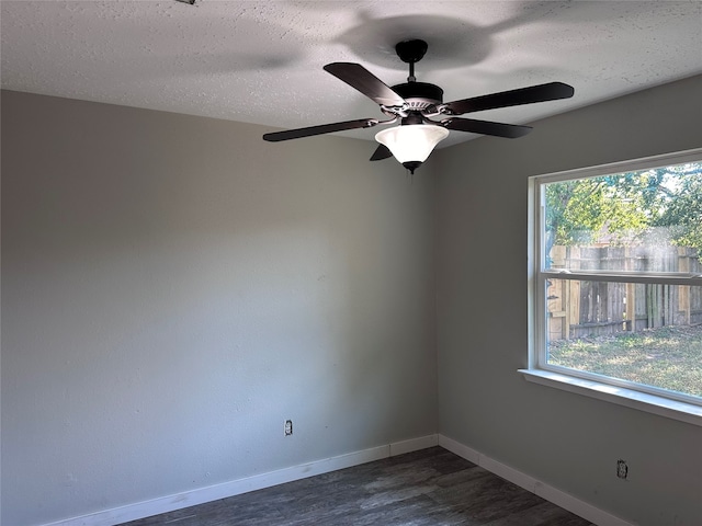 spare room with dark hardwood / wood-style flooring, ceiling fan, plenty of natural light, and a textured ceiling