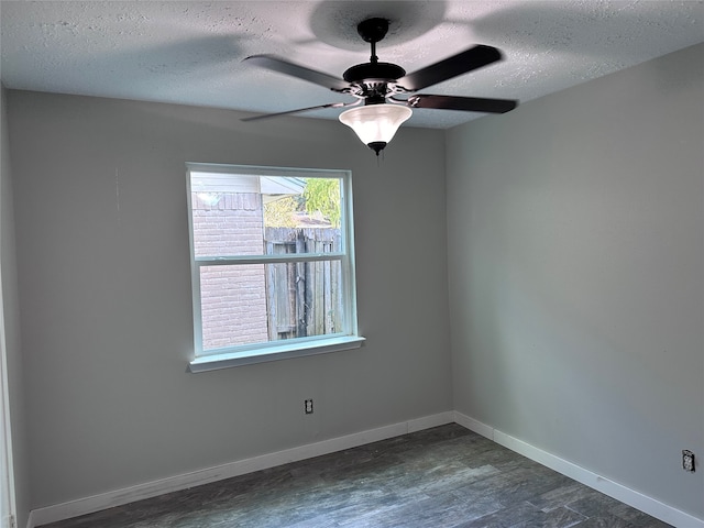 empty room with ceiling fan, a textured ceiling, and dark wood-type flooring